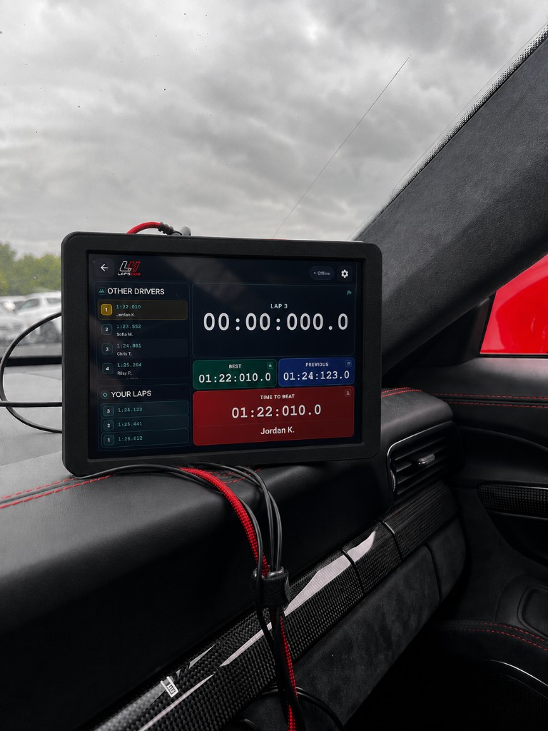 LapsHub Drive screen on a cockpit tablet showing Other Drivers, Your Laps, live lap timer, and Time to Beat while driving